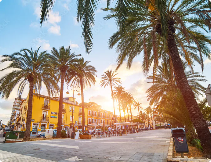 Palmeras en la playa al atardecer en Dénia, España