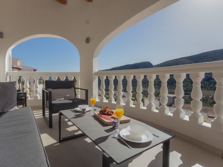 Covered terrace with dining area at Villa Vino in Pedreguer
