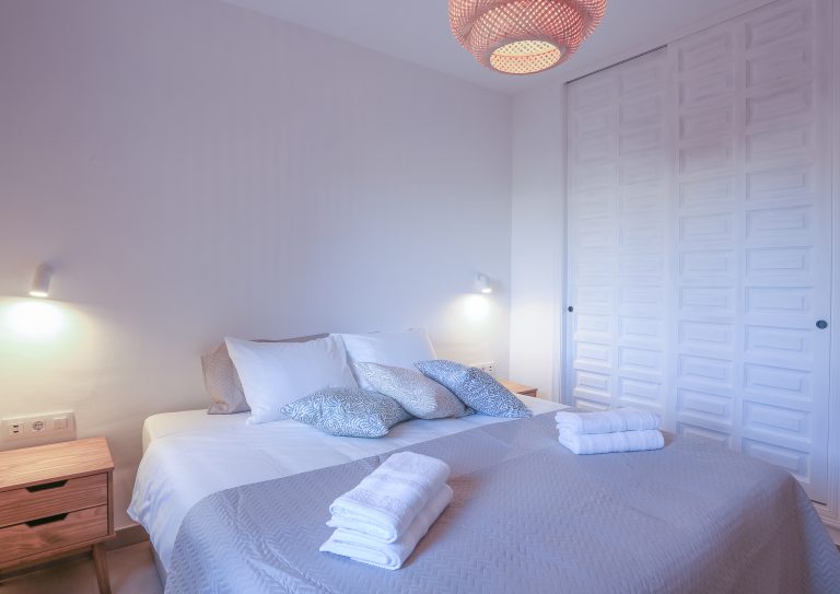Bedroom with bedside lamps at apartment Alquería Sol in Dénia
