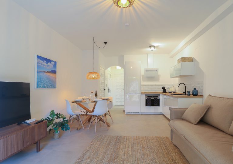 Living room with sofa and dining area at apartment Alquería Sol in Dénia