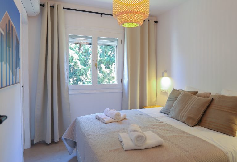 Bedroom with bedside lamps at apartment Montesol in Dénia