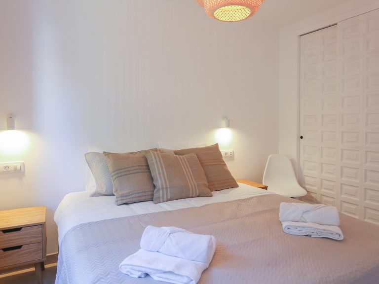 Bedroom with double bed and towels at apartment Montesol in Dénia