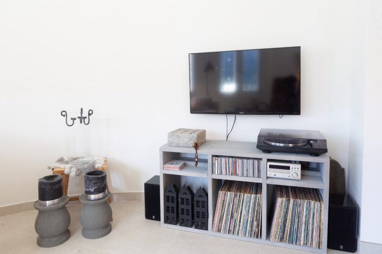 Living room with television and shelves at Villa Vino in Pedreguer