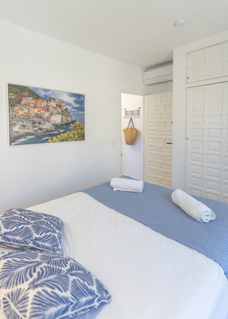 Bedroom with blue bedspread at apartment Retiro Sol A1 in Dénia