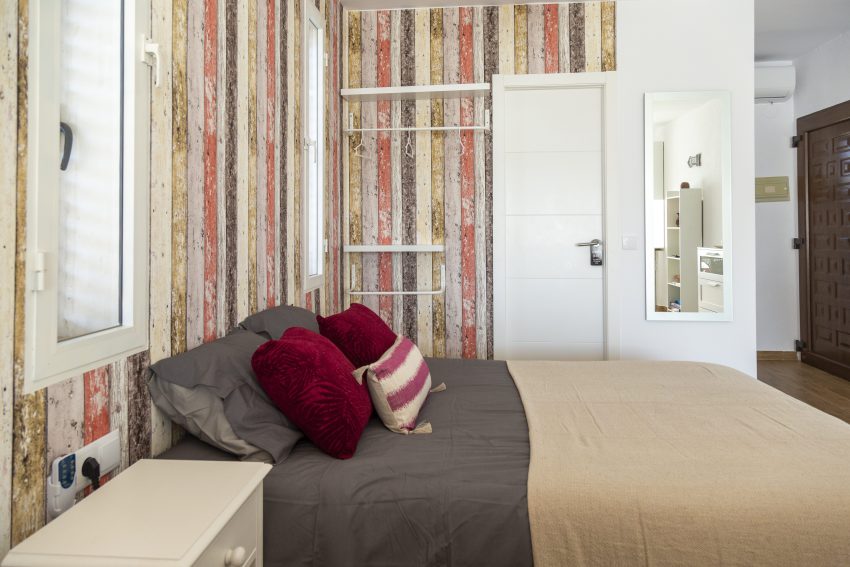 Bedroom with colourful wallpaper at apartment Retiro Sol A05 in Dénia