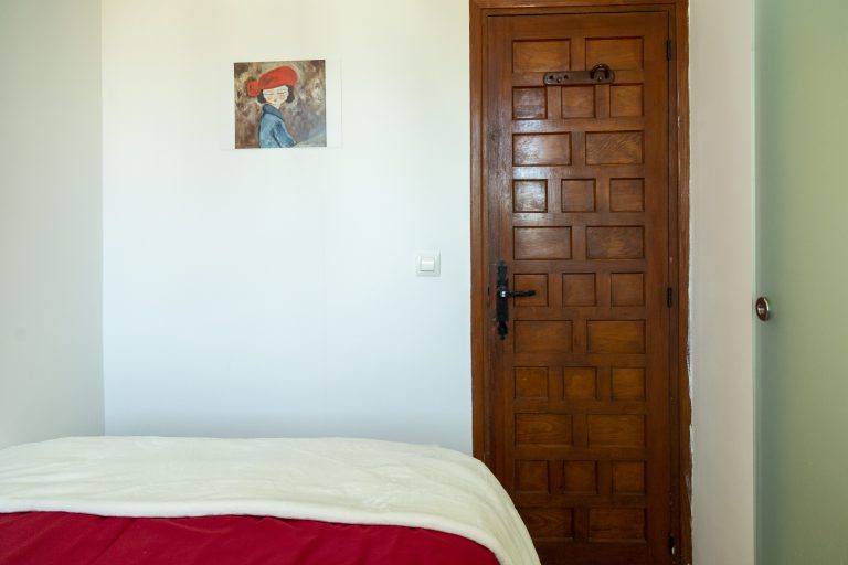 Bedroom with wooden door at apartment Retiro Sol A09 in Dénia