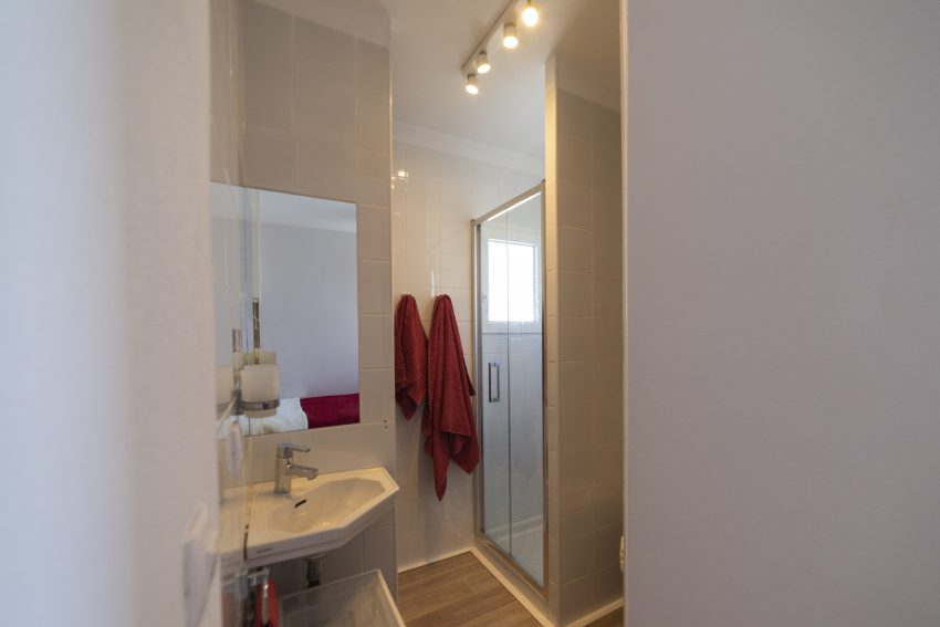 Bathroom with shower and red towels at apartment Retiro Sol A09 in Dénia
